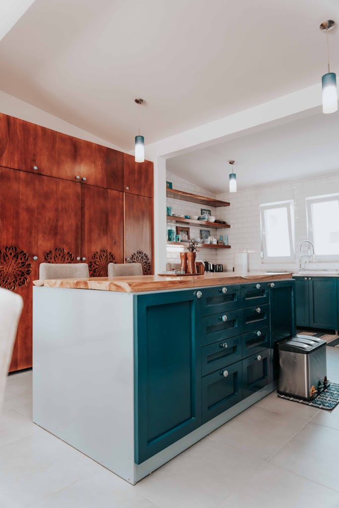 Stylish home kitchen with blue island and wooden cabinets, captured in bright lighting.