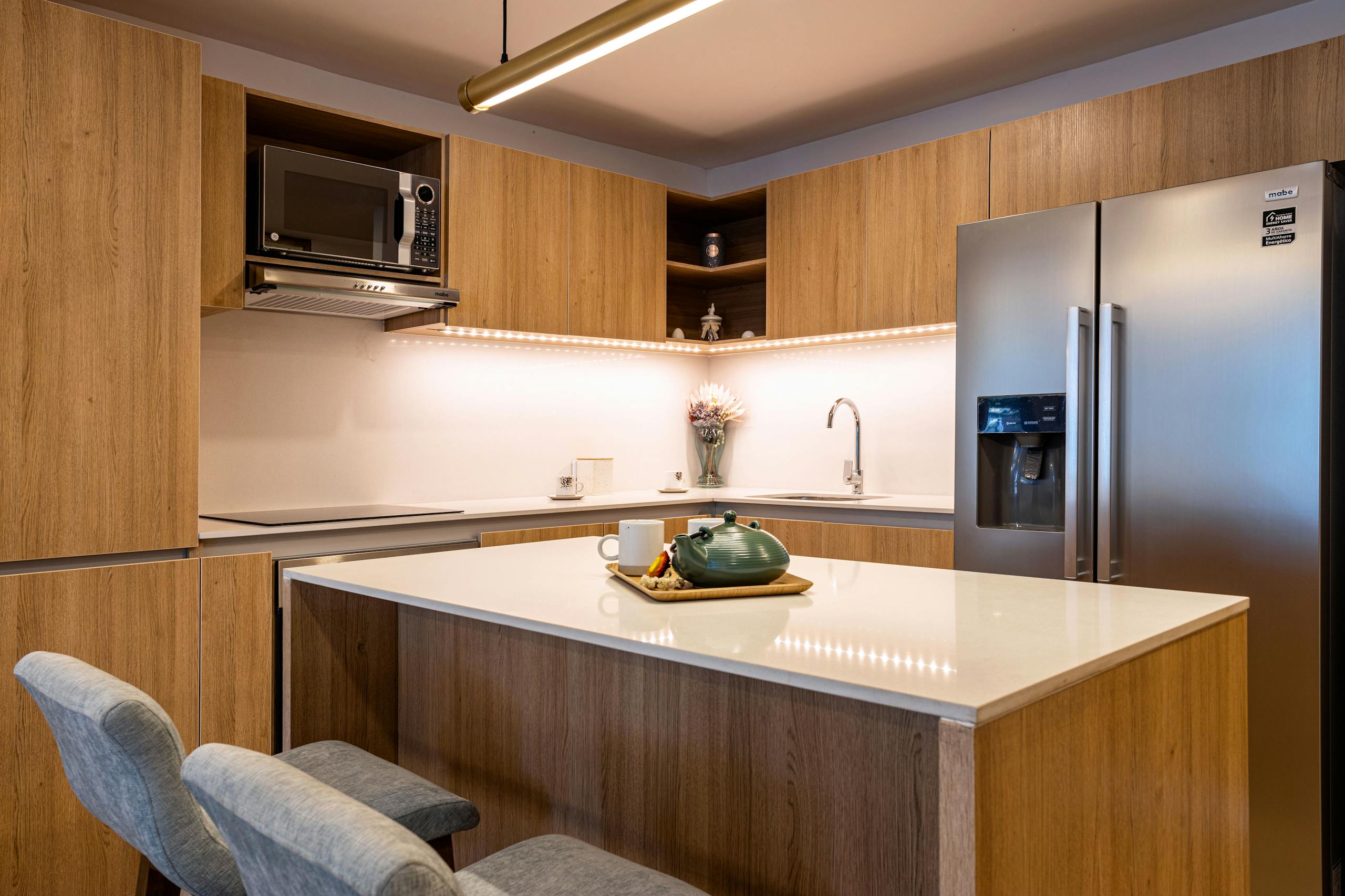 Stylish kitchen design with wooden cabinets and modern appliances in a Bogotá home.