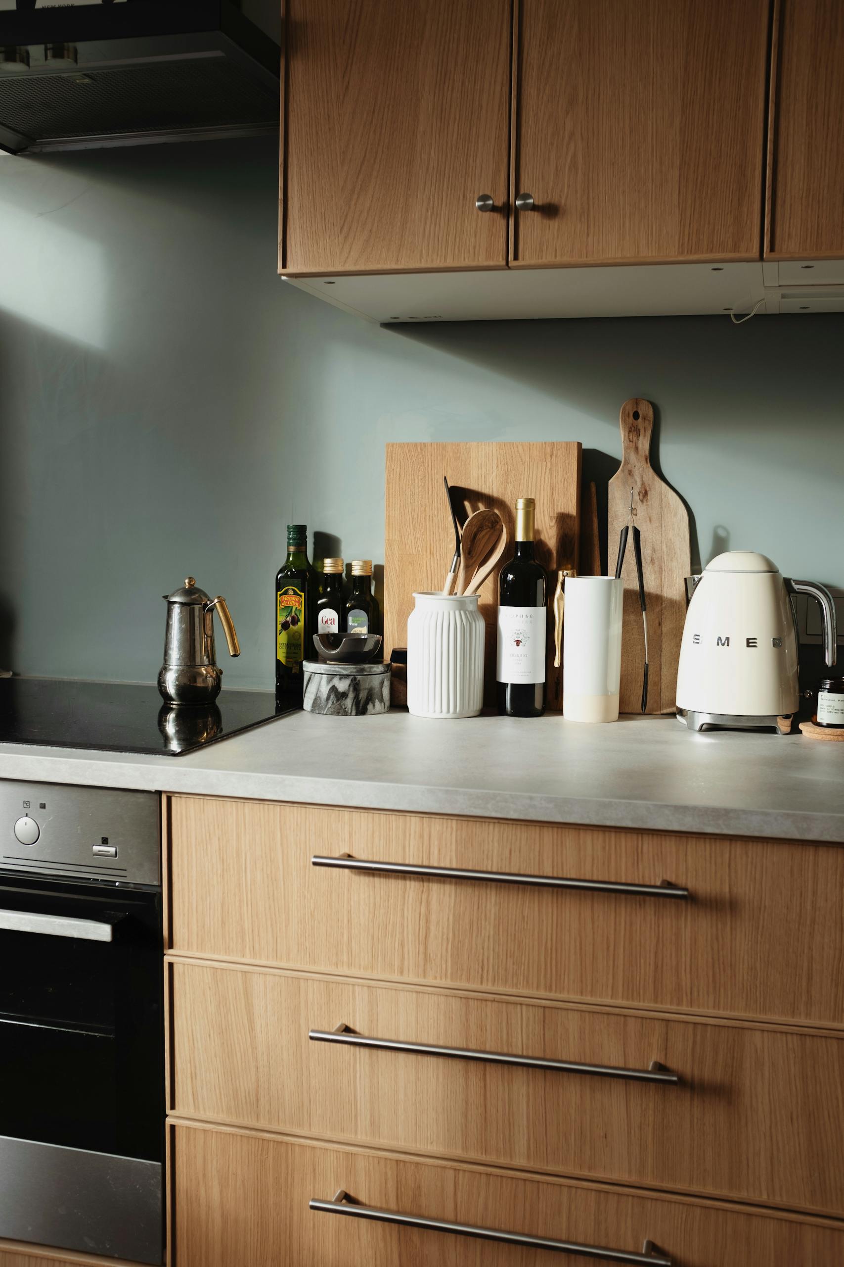 Stylish kitchen scene featuring SMEG kettle and cookware on a wooden countertop.